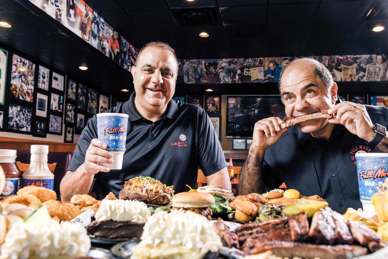 Full Moon Bar-B-Que owners David and Joe Maluff dive into some barbecue. The founders were at Madison’s grand opening Monday where they joined local franchise owner Brian Ahmed and other business and city leaders.